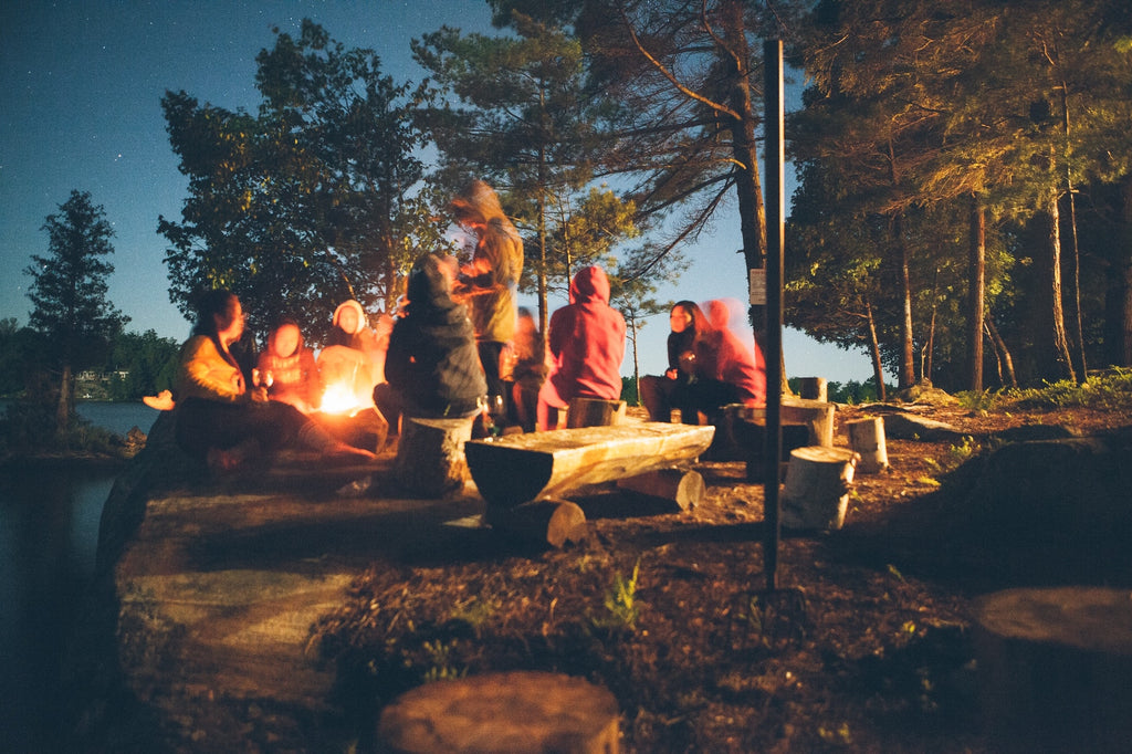 people sitting around a camp fire