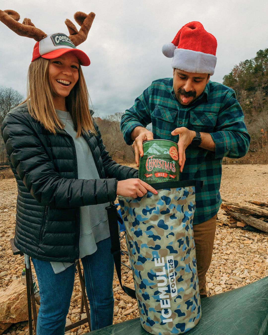 two people putting christmas ale in ICEMULE Mule camo on topp of canoe