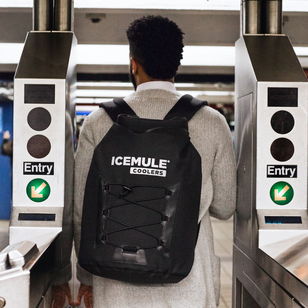 Man walking through subway entrance with Pro Large on back 