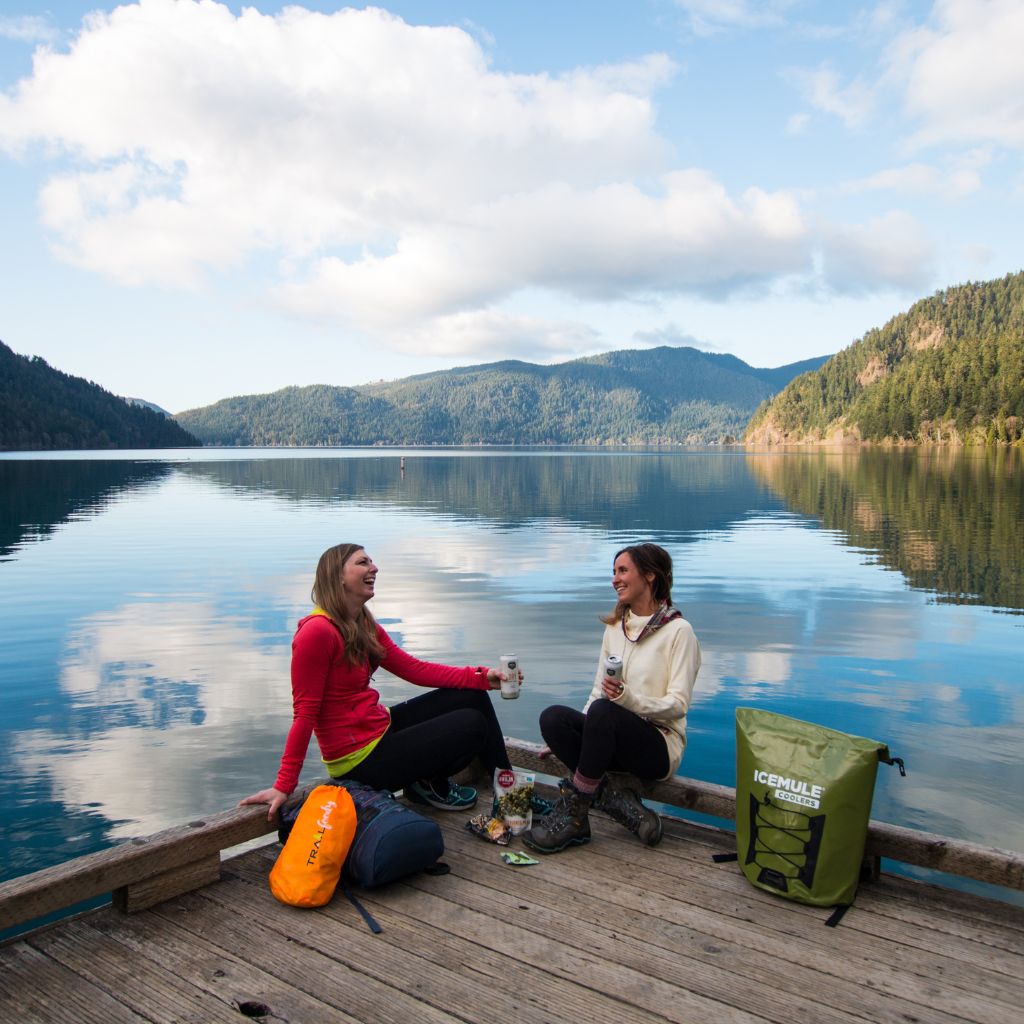 2 people sitting on lake in mountains with Pro large on dock 