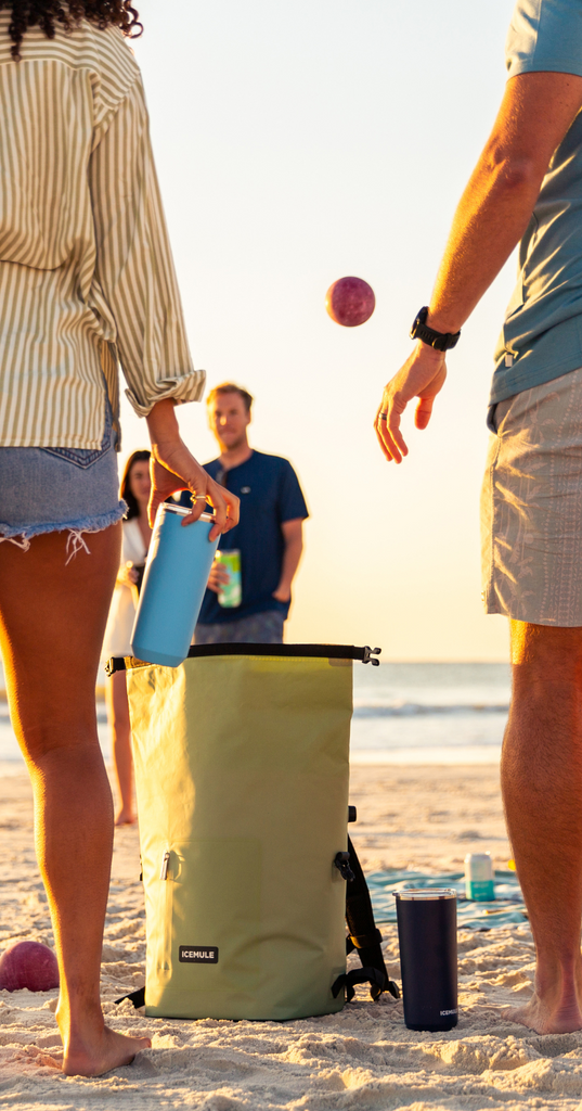 Playing a game on the beach with R-Jaunt at feet and people holding tumblers